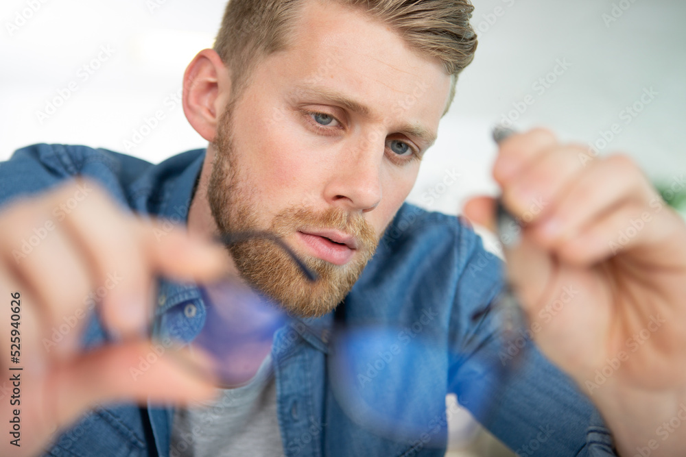 Obraz premium portrait of frowning businessman checking glasses