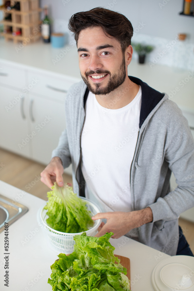 man preparing to spin washed lettuce man preparing to spin washed lettuce