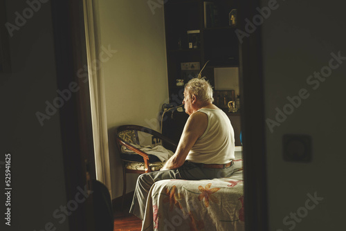 old man sitting on a bed