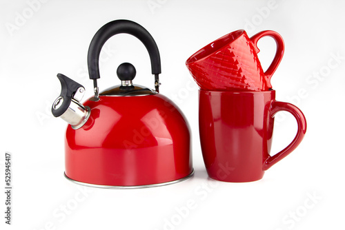 Red whistling kettle with two red mugs on a white background.