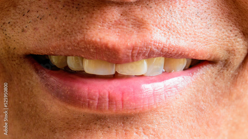 Tanned Asian man's lips with a close-up smile