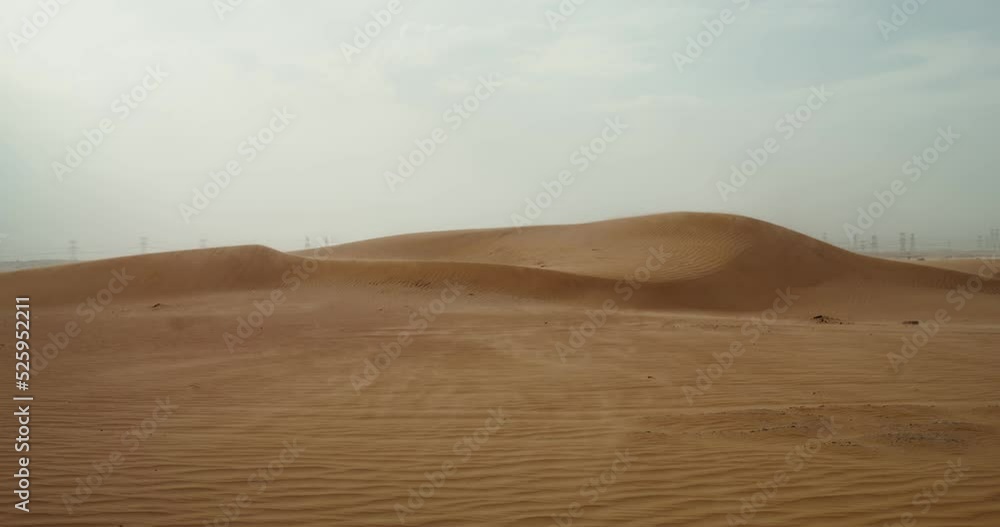 The wind inflates the sands of the desert, forming a beautiful sandy pattern. Desert sand dunes. Power lines in the background. 4k video, red komodo The wind inflates the sands of the desert, forming a beautiful sandy pattern. Desert sand dunes. Power lines in the background. 4k video, red komodo