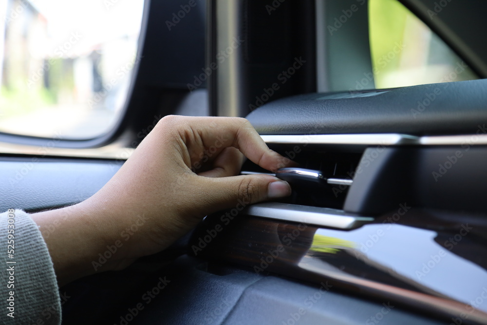 Closeup female hand adjusting air ventilation grille