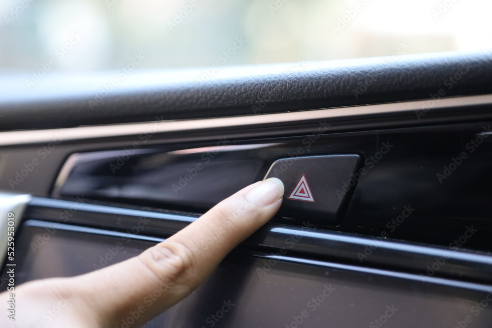 Finger hitting emergency light stop botton in the car , man pressing red triangle car hazard warning button. car emergency button