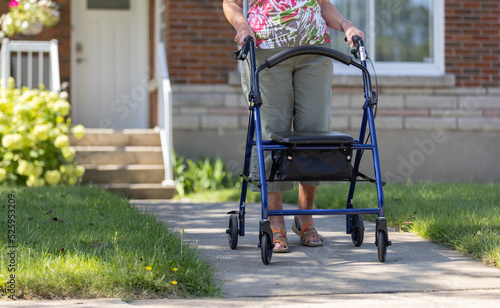 Foto Old woman walking outside with a rollator