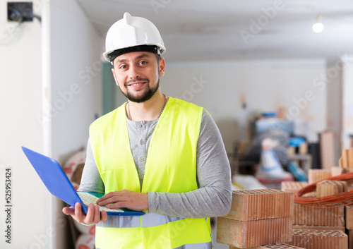 Young adult man interior designer developing concept of space planning using laptop at renovating object