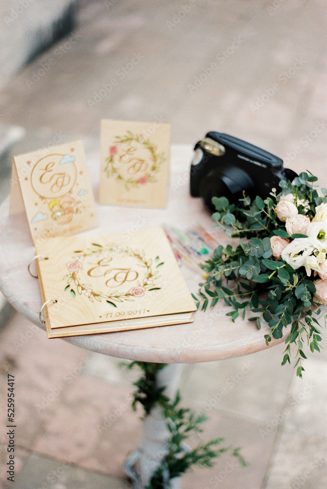 Wedding album with cards and flowers stands on the table