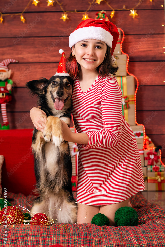 Obraz premium brazilian child celebrating christmas with smiling mutt dog vertical photo