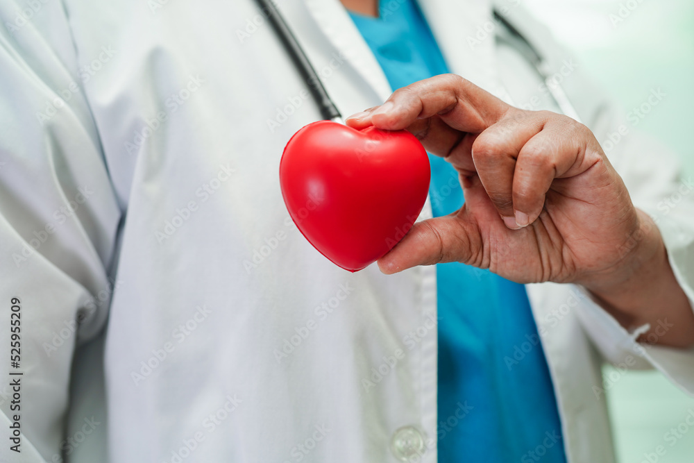 Asian woman doctor holding red heart for health in hospital. Asian woman doctor holding red heart for health in hospital.