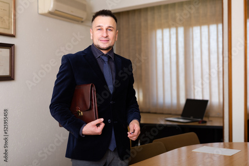 Portrait of positive businessman in meeting room of a modern office