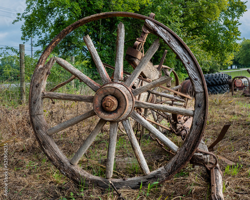 Weathered old cracked and rusted wooden spoked wagon wheel.