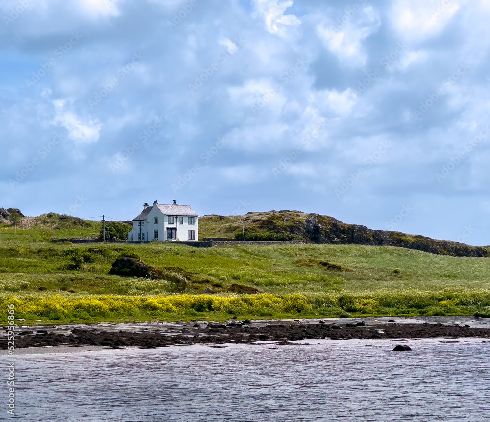 Large, isolated, white house on the Scottish coastline of the Isle of Islay
