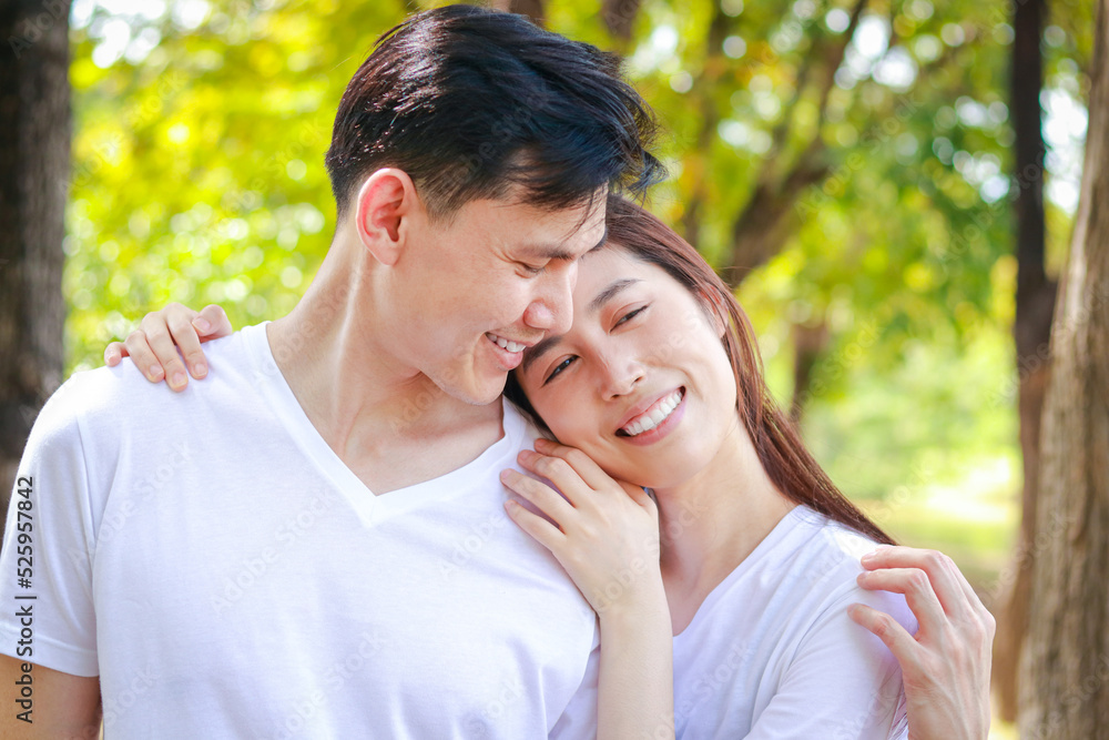 Asian couple wearing white shirts Happy smiling in the park. Family concept. Healthy health care. outdoor exercise Asian couple wearing white shirts Happy smiling in the park. Family concept. Healthy health care. outdoor exercise