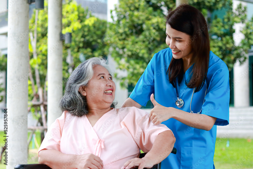 Asian female doctor treats an elderly patient sitting in a wheelchair. Concept of medical services in hospitals. surgical treatment of patients Asian female doctor treats an elderly patient sitting in a wheelchair. Concept of medical services in hospitals. surgical treatment of patients