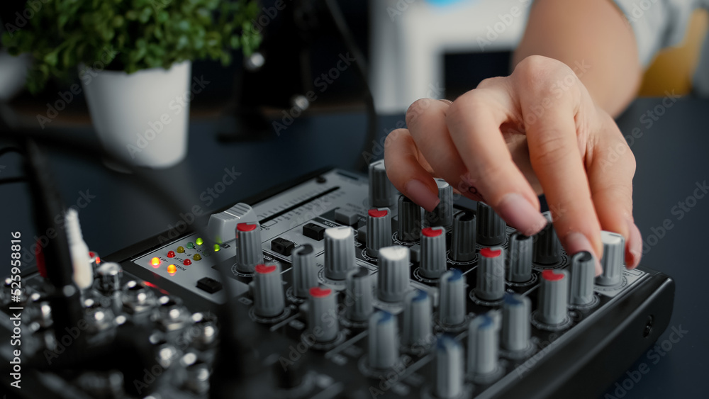 Internet famous star tweaking audio mixer knobs and buttons. Internet radio host changing volumes and using studio sound console equalizer to improve broadcast audio quality. Close up shoot Internet famous star tweaking audio mixer knobs and buttons. Internet radio host changing volumes and using studio sound console equalizer to improve broadcast audio quality. Close up shoot