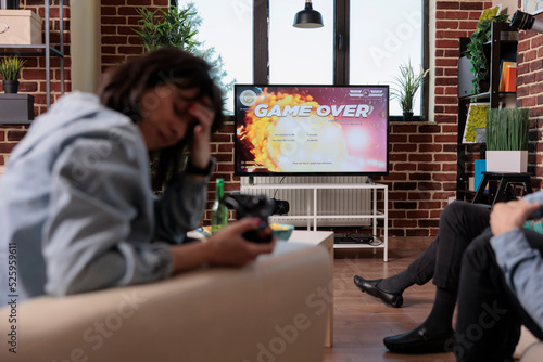 Competitive woman losing after playing shooter video games, feeling frustrated about lost competition. Sad angry person using gaming console to play shooting game, strategy lose.