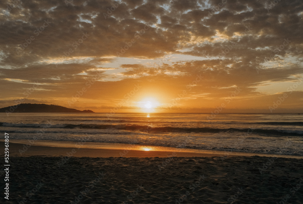 Sunrise on the beach with girl walking near the ocean