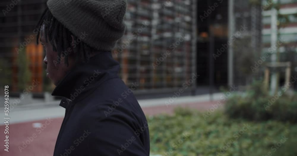 Portrait young african american man standing near the office building and looking at camera. Handsome dark-skinned guy on the street Portrait young african american man standing near the office building and looking at camera. Handsome dark-skinned guy on the street