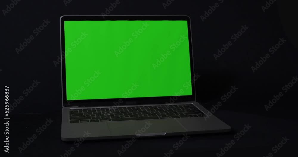 Slider shot of modern notebook with green screen on black background.
Slider shot of modern notebook with green screen on black background.
