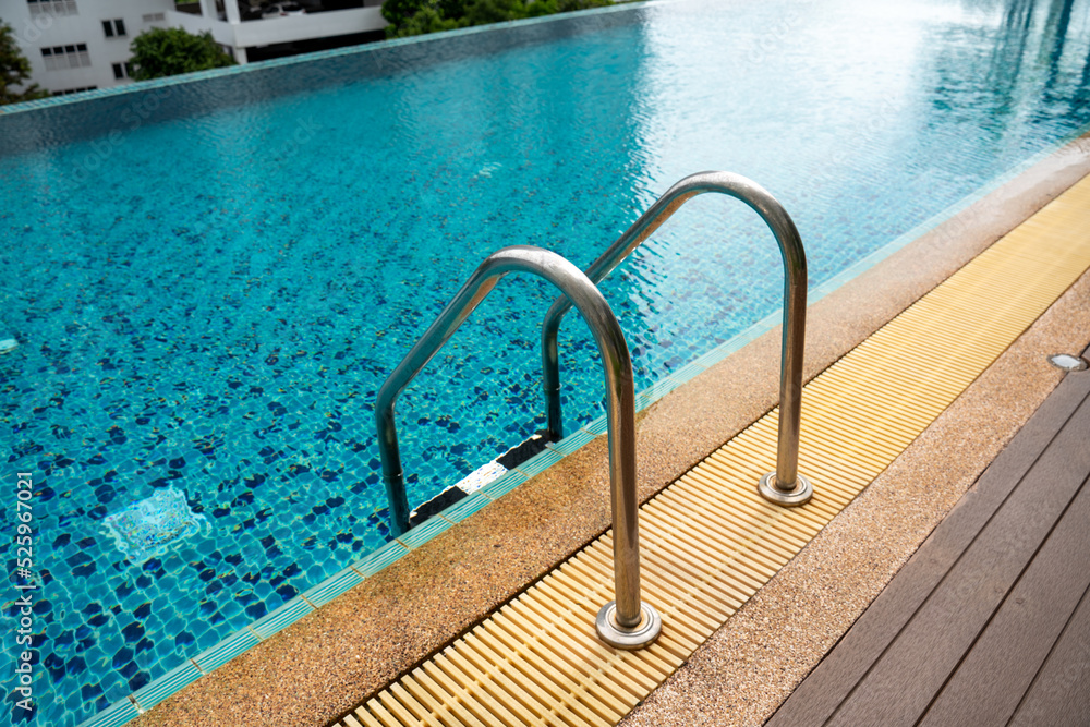 Swimming pool with stair and wooden deck at hotel or Condominium