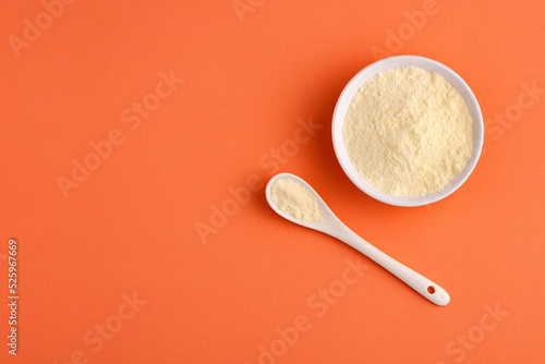 Powdered or dehydrated milk in the bowl and spoon