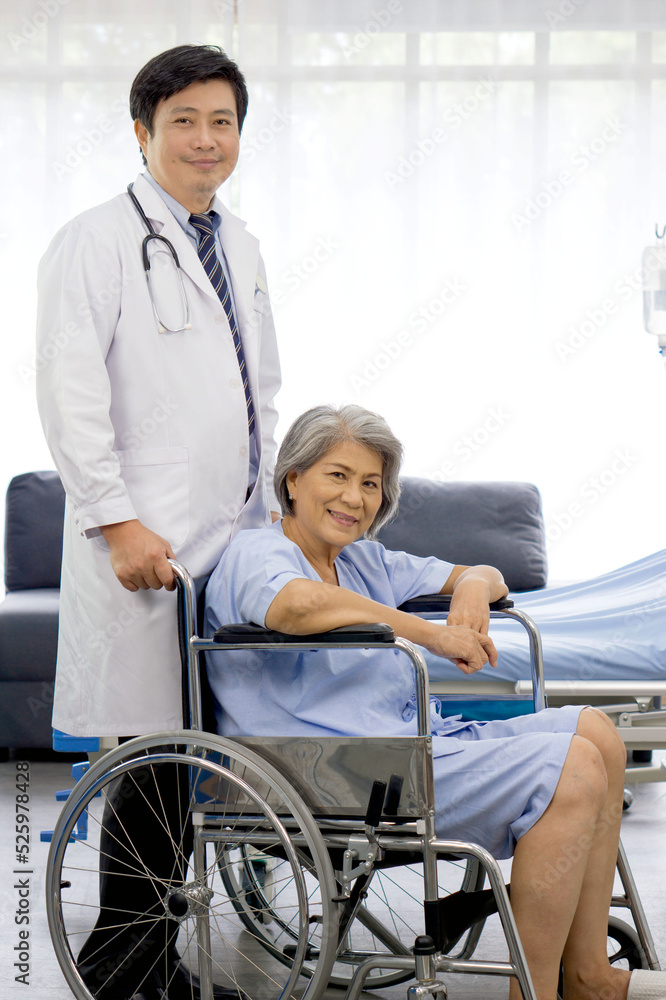 Portrait of asian doctor with stethoscope and gown push a wheelchair of the elderly patient. Healthcare and medicine concept. Portrait of asian doctor with stethoscope and gown push a wheelchair of the elderly patient. Healthcare and medicine concept.