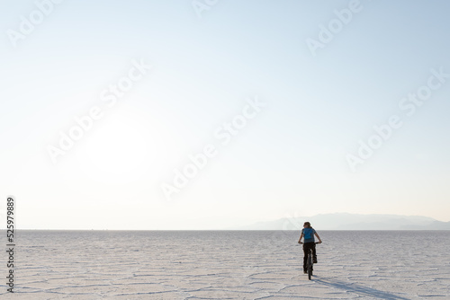 Young woman riding a bike on Bonneville Salt Flats in Utah