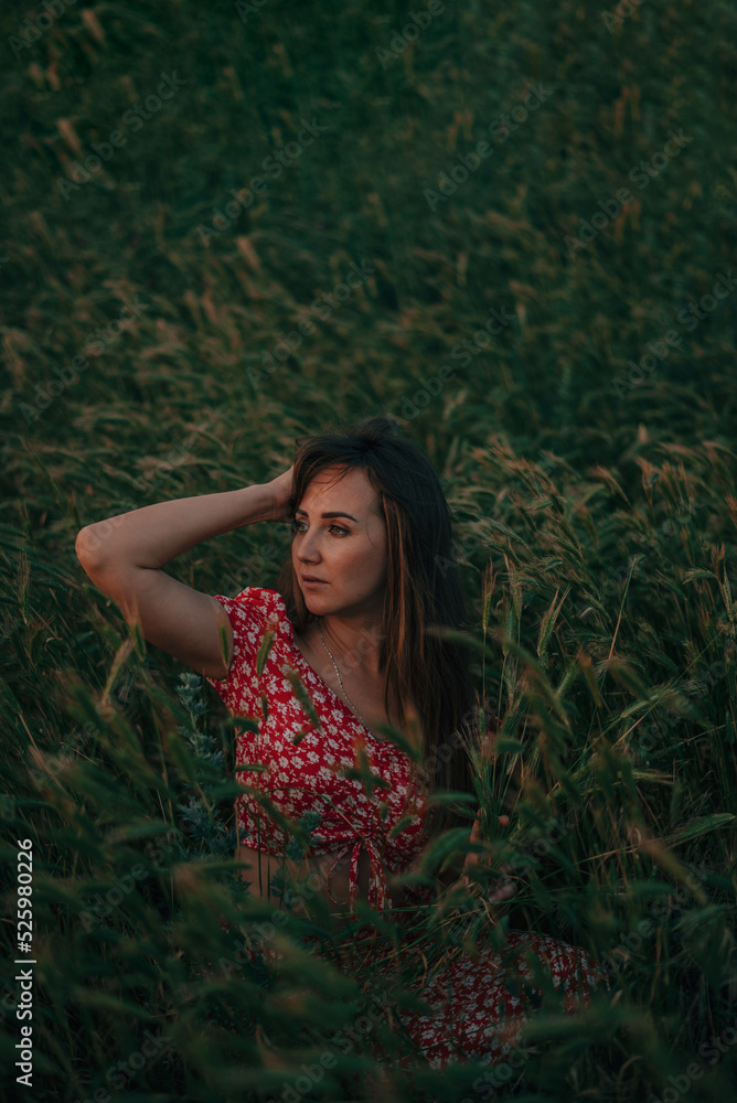 portrait of young woman in summer in tall grass