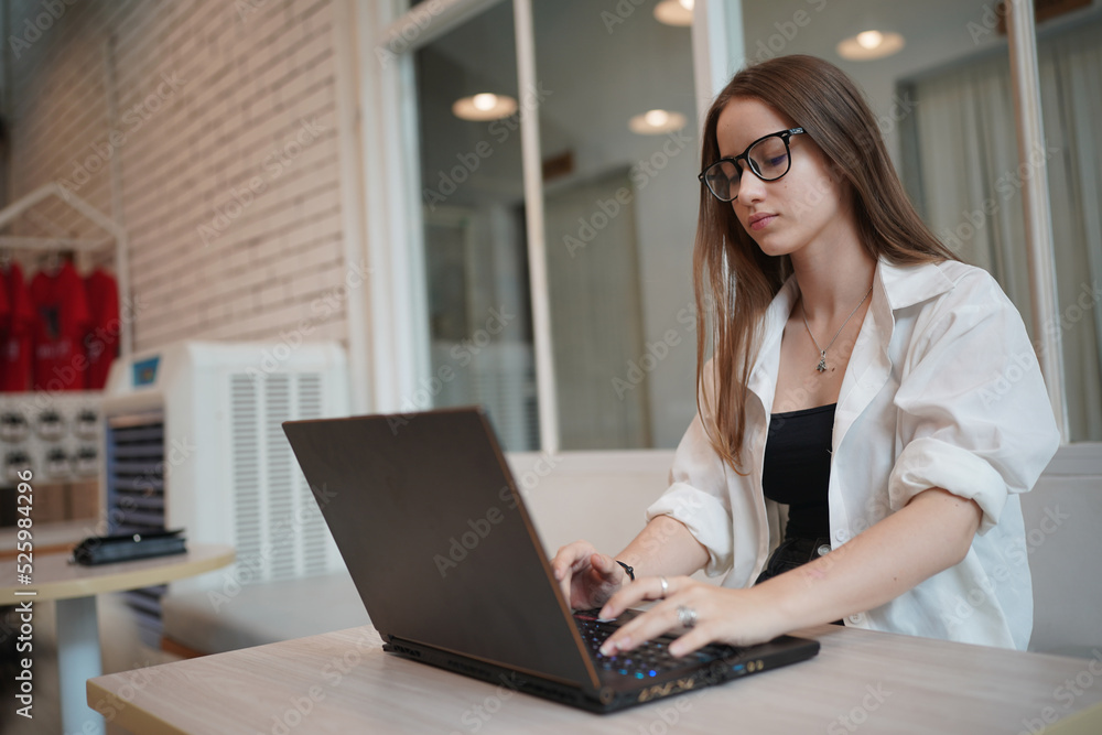 Technology and people concept, young woman using laptop and internet technology and sitting on the desk with laptop computer. Technology and people concept, young woman using laptop and internet technology and sitting on the desk with laptop computer.