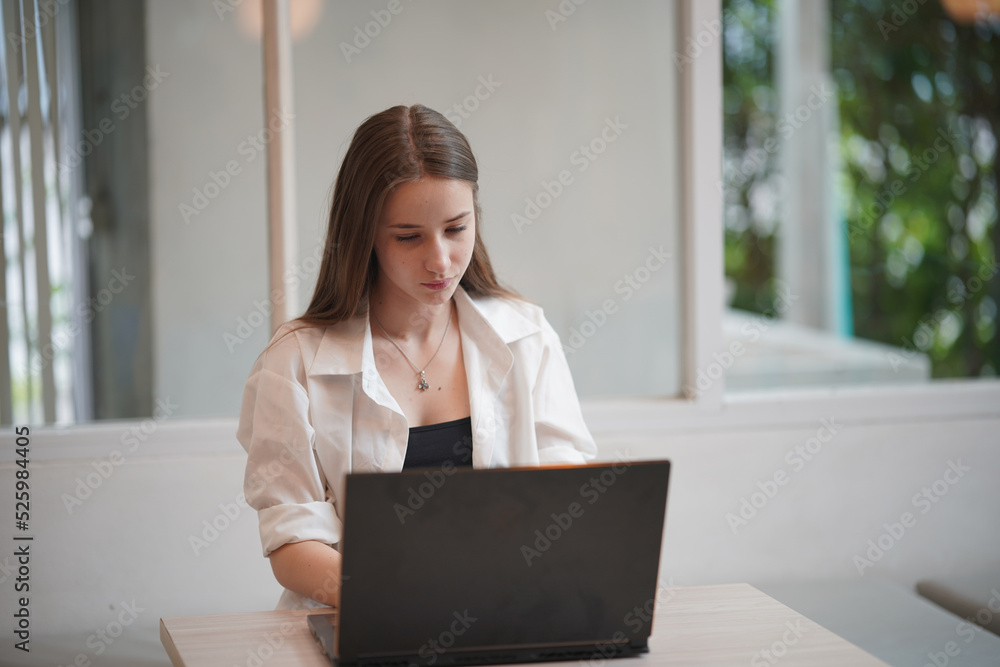 Technology and people concept, young woman using laptop and internet technology and sitting on the desk with laptop computer. Technology and people concept, young woman using laptop and internet technology and sitting on the desk with laptop computer.