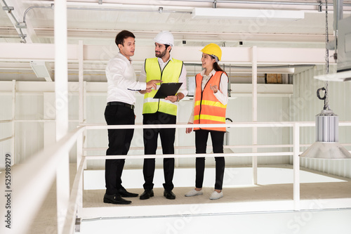 Young Asian engineer or building inspector checking interior building detail with female construction worker by using check list and drawing. Two building worker inspecting interior building. photo