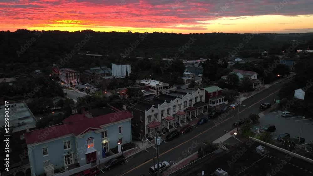 Colorful sunrise in downtown city. Residential houses as car drives by. Early morning darkness. Aerial view. Colorful sunrise in downtown city. Residential houses as car drives by. Early morning darkness. Aerial view.