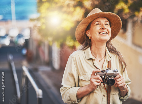 Happy photographer tourist taking photo of historic building with camera, smiling and carefree. Excited mature female solo travel journey, enjoying retirement while looking at bucket list destination photo