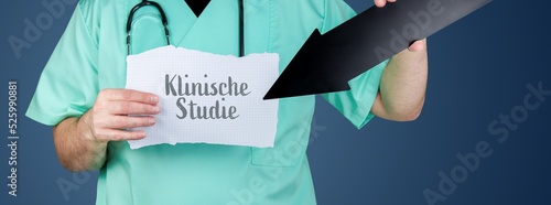 Klinische Studie. Arzt hält Zettel und zeigt mit Pfeil auf medizinischen Begriff. photo