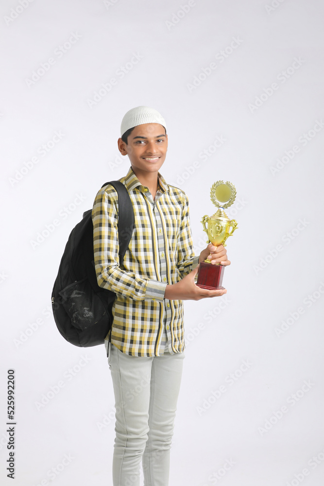 Indian college boy showing trophy and giving expression on white background. Indian college boy showing trophy and giving expression on white background.