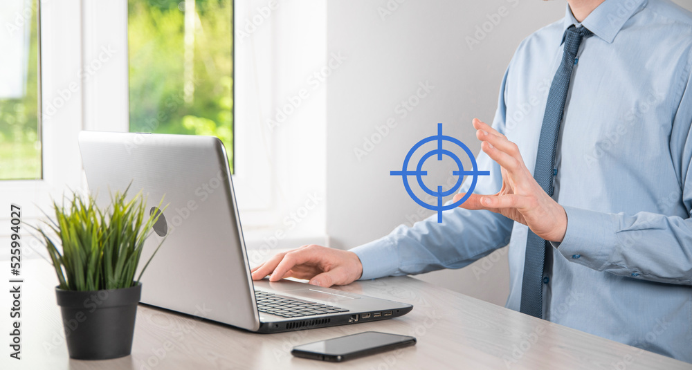 Targeting concept with businessman hand holding target icon dartboard sketch on chalkboard. Objective target and investment goal concept. Targeting concept with businessman hand holding target icon dartboard sketch on chalkboard. Objective target and investment goal concept.