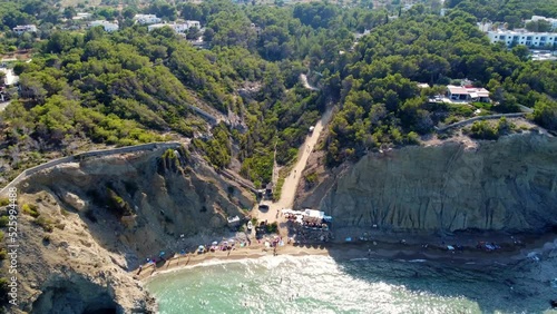 Small beach bar on nudist hippie beach on Ibiza parasol with long shade
Smooth aerial view flight fly forward drone footage of Aigües Blanques summer day july 2022 Marnitz 4k Cinematic view from above photo