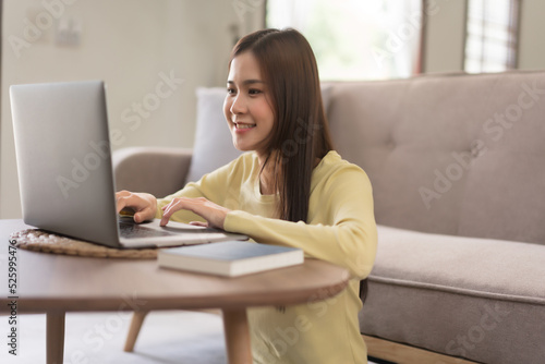 Relaxation concept, Young woman use laptop and typing on keyboard while sitting to relax on floor