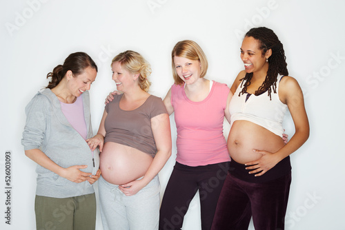Pregnant, health and wellness with a group of woman friends expecting a baby in studio against a white background. Mother, family and children with happy women with a smile and happy in pregnancy