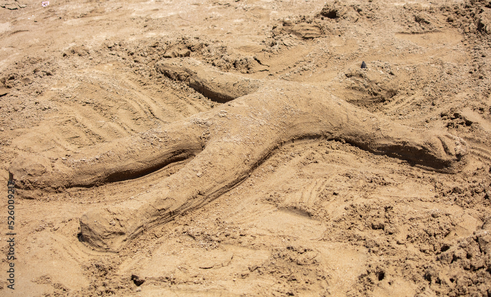 A man made of sand on the beach