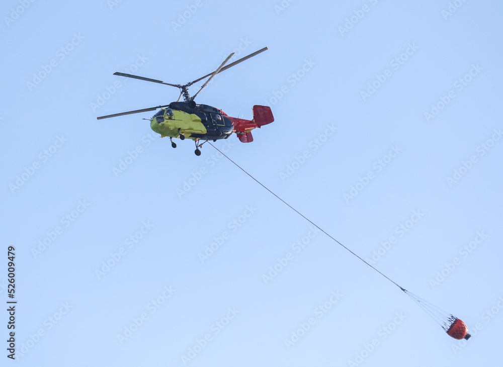 Helicopter with water to extinguish a fire Helicopter with water to extinguish a fire