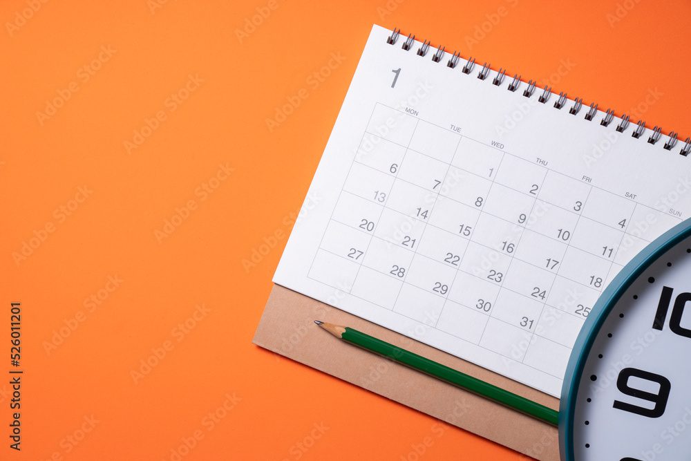close up of calendar and clock on the orange table background, planning for  business meeting or travel planning concept Photos