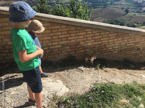 Kinder laufen Straßenkatze hinterher, Treppen in Italien photo