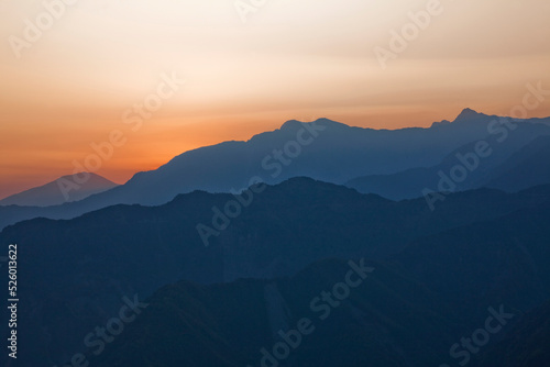 Sunrise view of magnificent layered mountains with colorful clouds background