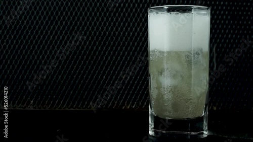 Beer in a deep glass with ice cubes