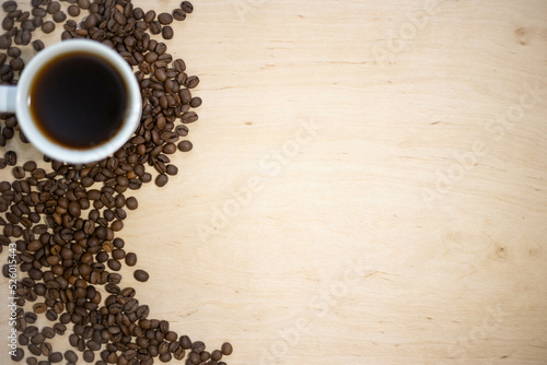 Coffee beans on a wooden background. Cup of coffee and coffee beans.