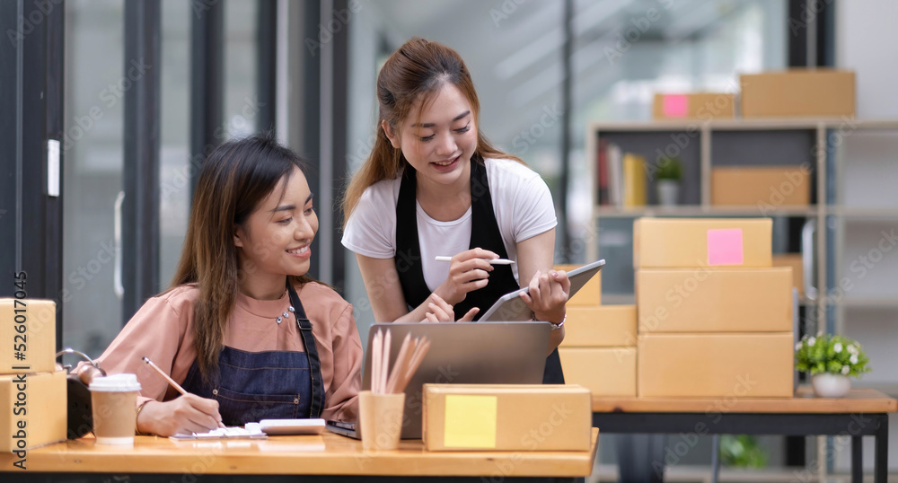 Portrait of Starting small businesses SME owners, two Asian woman check online orders Selling products working with boxs freelance work at home office, sme business online small medium enterprise Portrait of Starting small businesses SME owners, two Asian woman check online orders Selling products working with boxs freelance work at home office, sme business online small medium enterprise