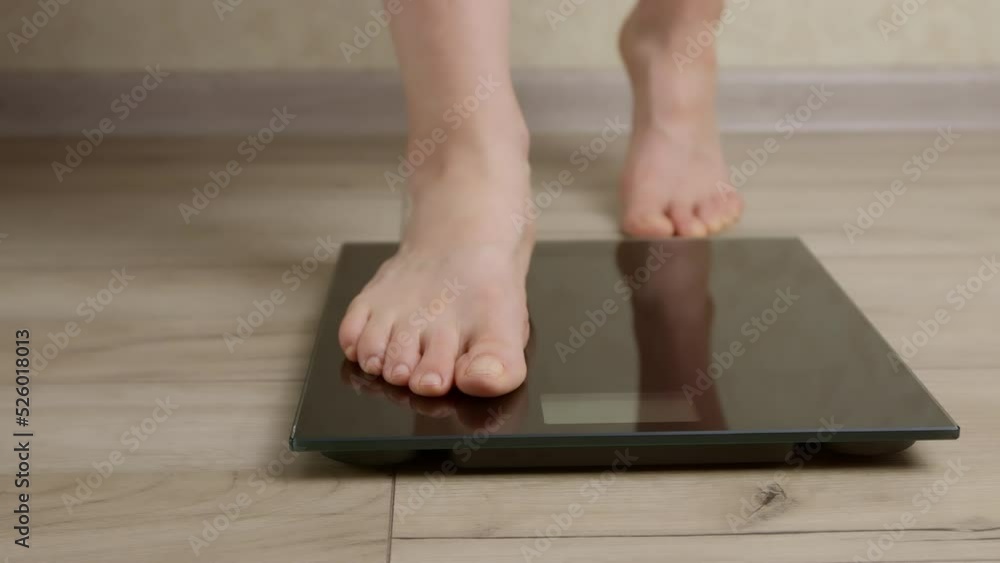 Feet of a woman standing on the scales for weighing. Feet of a woman standing on the scales for weighing.