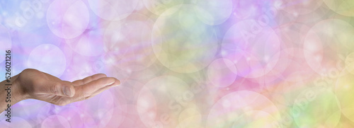 Rainbow Bubble Message Banner Template - male hand with open palm in bottom left corner against a wide multicoloured bubble bokeh background with space for text 
