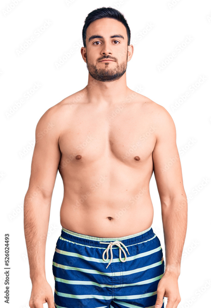 Fototapeta premium Young handsome man wearing swimwear looking sleepy and tired, exhausted for fatigue and hangover, lazy eyes in the morning.